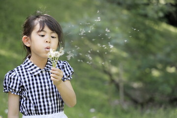 タンポポを吹く女子小学生 (6歳)