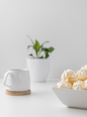 cream meringues in a bowl with cup on a white background 
