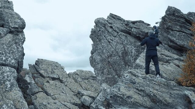 Hicker Standing On The Top Of The Cliff Looking Sideways Enjoying The Mountain Scenery. Travel Concept Active People on the Way to Victory Move Forward