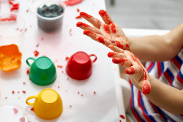 The child smeared his hands in kinetic sand. An educational game of kinetic sand with the use of...
