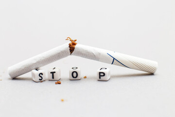 broken cigarette with the word stop on gray background close. stop smoking concept