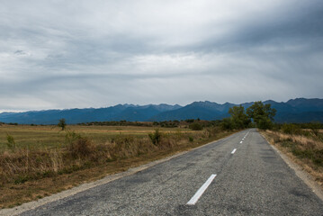 A road that leads to the mountains, on a cloudy day