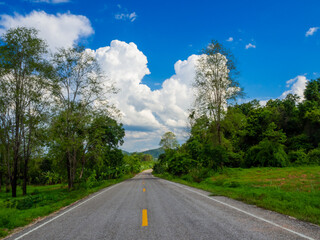 wide asphalt highway with road markings against a blue sky with clouds. Summer sunny day.