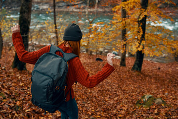 woman with backpack travel tourism forest landscape park river fallen leaves side view
