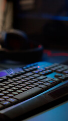 Close up of professional RGB keypad in empty gaming room prepared for streaming online tournament, display with first person shooter playing on it. Game studio with powerful computer © DC Studio