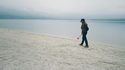 A man walking by the lake in Osorezan, Japan.   