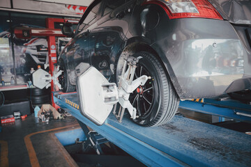 Car wheel balancer calibrate with laser reflector attach on each tire to center driving adjust. Car...