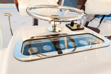 Internal control cabin of a motor yacht. Control panel, steering wheel and gear levers.