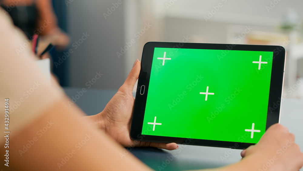 Poster tablet computer with mock up green screen chroma key display standing on table desk. freelancer woma