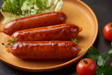 sausages and ingredients for cooking. Grilled sausage with the addition of herbs and and spices, vegetables, rosemary, thyme on the grill plate, Grilling food, bbq, barbecue, on stone table. Top view.