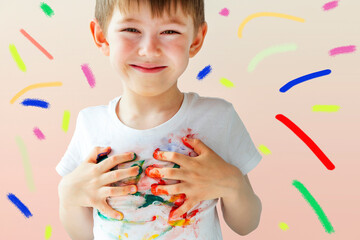 Joyful cute preschooler little boy 5-6 years with colorful painted hands. Kid painted T-shirt with...