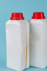 Two white containers with lid for liquids on blue background.