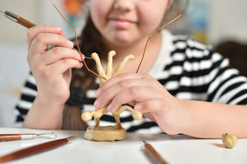 Teenager learning to sculpt figures from plasticine, children's creativity concept