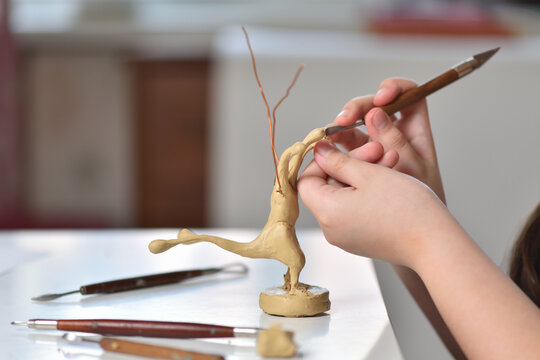 Teenager learning to sculpt figures from plasticine, children's creativity concept