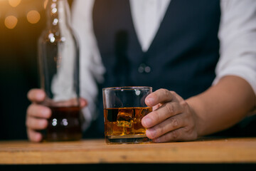 Barman pouring whiskey glass on beautiful bokeh background