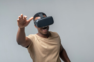 Smiling man in VR glasses waving his hands