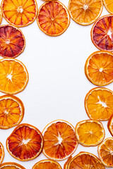 Bright summer layout. Citrus background and blank sheet paper. Slices of dried red oranges on a white.