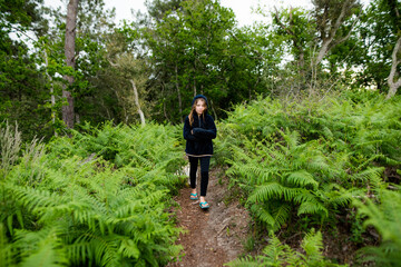 Obraz premium cute young girl walking in the forest with her dog