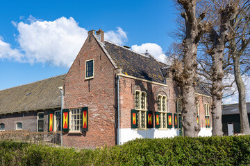 A beautiful old farmhouse with colorful shutters on the windows between the bulb fields around the city of Lisse