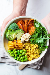 Vegan breakfast bowl - scrambled tofu, corn, beans, sweet potato and broccoli. Plant-based diet concept.