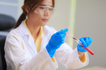 Closeup female doctor in labcoat wearing nitrile gloves, doing experiments in lab, academic sector.