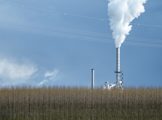 smoking chimney of a factory against sky in Germany