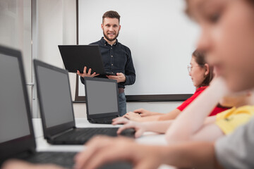 Company of children using laptops during lesson