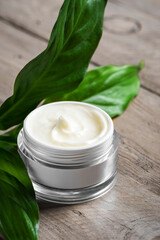 Cosmetic cream and green leaves
