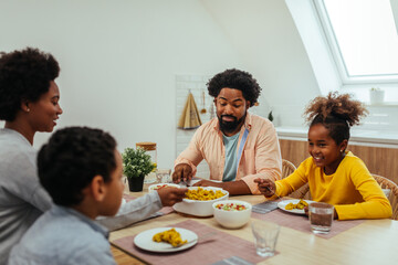 Cute afro family having lunch together at home