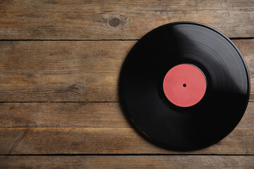 Vintage vinyl record on wooden background, top view. Space for text