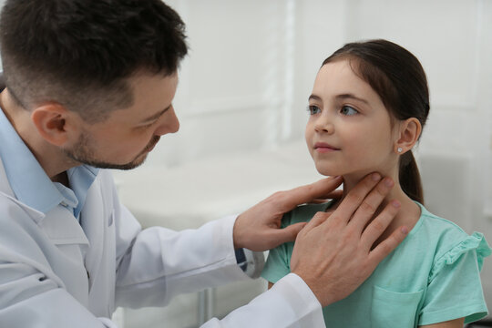 Pediatrician examining little girl in office at hospital
