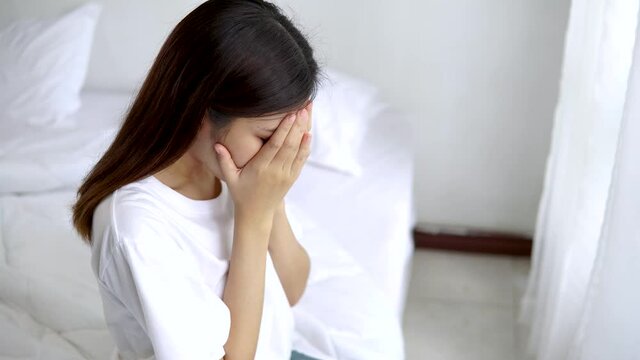 Psychologist touches a depressed Asian woman for encouragement. Woman crying and then friend's hand came to her shoulder to comfort and encourage.