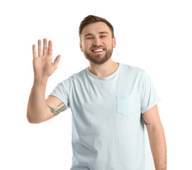 Happy young man waving to say hello on white background © New Africa