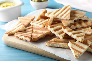 Delicious pita chips on light blue wooden table, closeup