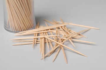Disposable wooden toothpicks on grey background, closeup