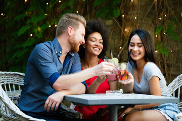 Multiracial group of friends having fun and talking in restaurant