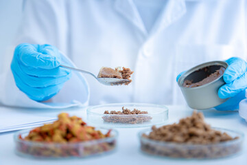 Close up picture of quality control personnel are inspecting the quality of canned pet food. Physical quality inspection. Quality control process of pet food industry.