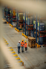 Three business people with safety helmet at warehouse