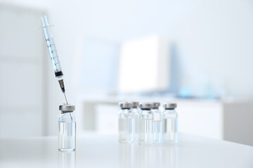Syringe with vial of medicine on white table