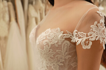 Woman trying on wedding dress in boutique, closeup