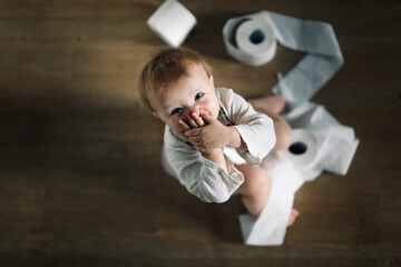 Funny kid baby Toddler sits on a pot with toilet paper, concept of teaching pot, child autonomy....