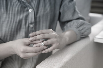 Woman taking off wedding ring indoors, closeup. Cheating and breakup