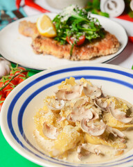 Italian food on Italian flag background, top view, flat lay. Pasta, shrimps, cream soup with pumpkin seeds.