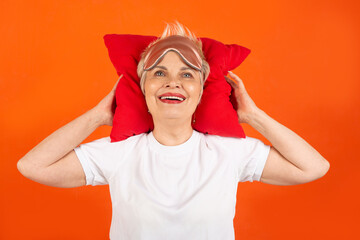 beautiful adult woman aged with a pillow on a red background 