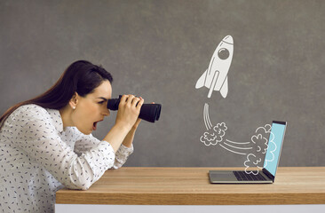 Side profile view astonished lady looking in binoculars at rocket flying out laptop computer...