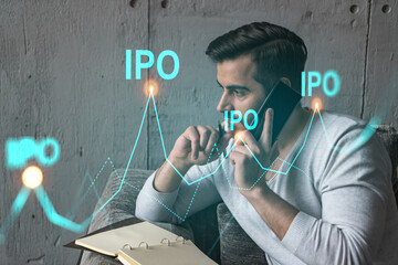 Handsome analyst in casual long sleeve talking phone, taking notes at office workplace try to...