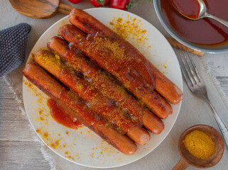 overhead view of fried sausages with spicy curry sauce on a plate