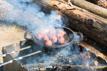 Vegan falafel cook in a pan outdoors. Middle east culture. Wood fire prepared for grill on nature. Picnic.
