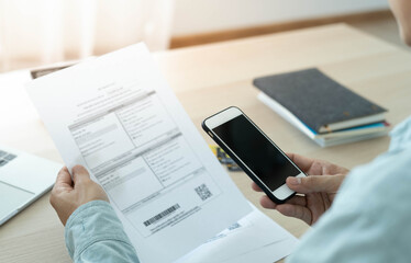 Fototapeta premium A businessman uses a smartphone to scan barcode by connecting to the internet from 5G signal to access online payment applications. Pay without cash concept