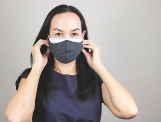 Asian woman wearing  double face masks  or two face masks for better protection  from coronavirus or covid-19 outbreak - concept of safety, healthcare, medical and hygiene.